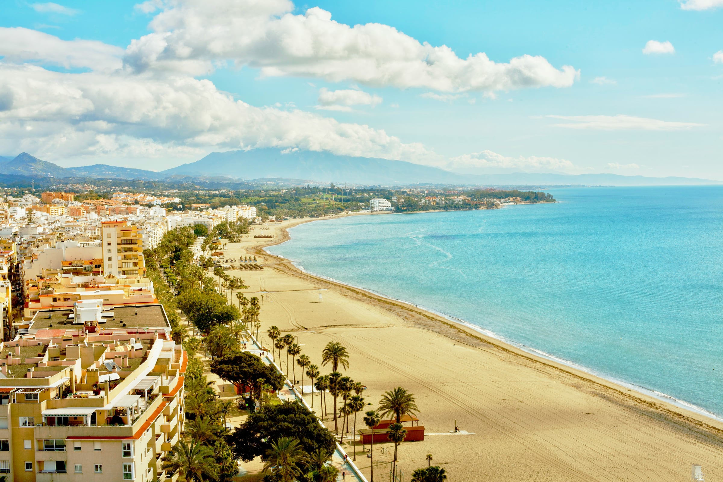Vista de la playa de la Rada, en Estepona, con el pueblo y la sierra al fondo